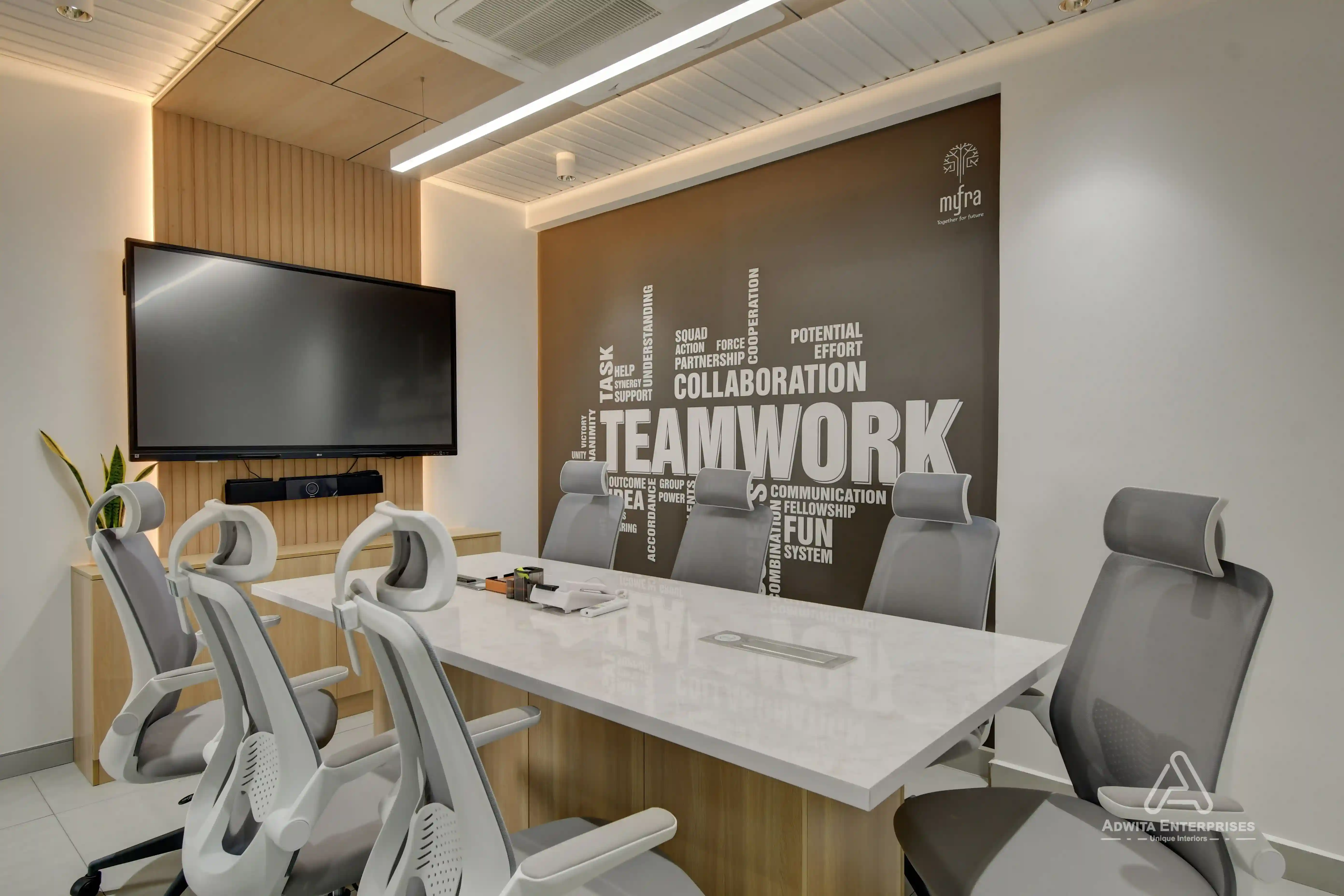 Discussion room with large conference table, ergonomic chairs, and modern lighting